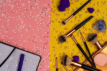 Cosmetic brushes with notebook and pen, top view