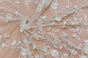 Texture lace fabric. lace on white background studio. thin fabric made of yarn or thread. a background image of ivory-colored lace cloth. White lace on beige background.