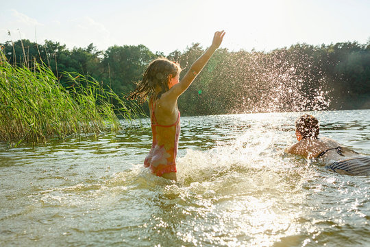 Mother and daughter swimming in lake