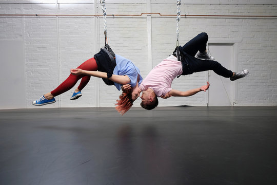 Modern aerialist dancers performing, hanging upside-down