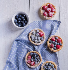 Cakes with fresh fruits on a white wooden background Top view