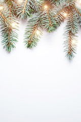 Fir branches on white wooden background. Christmas wallpaper. Flat lay, copy space.