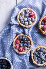 Cakes with fresh fruits on a white wooden background Top view