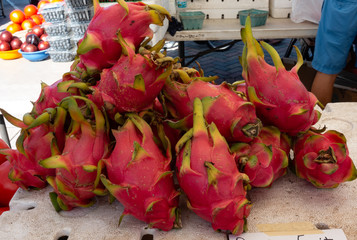 Dragon fruit at a farmers market produce stand.