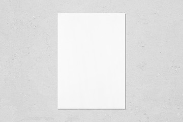 Empty white vertical rectangle poster mockup with soft shadow on neutral light grey concrete wall...