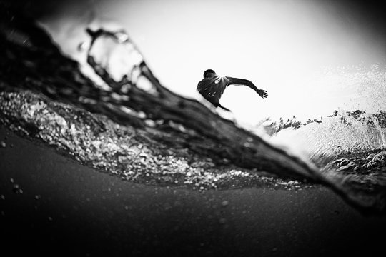 Male surfer making cutback from behind ocean wave