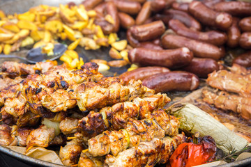 Kebabs of meat, sausages, potatoes in a rustic style fried in a large pan. The concept of fast food, street restaurants and fairs.