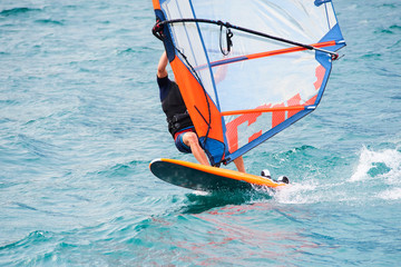 Naklejka premium Windsurfing on Lake Garda. Unidentifiable Windsurfer Surfing The Wind On Waves, Recreational Water Sports, Selective focus