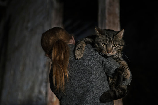 Girl holding cat over shoulder