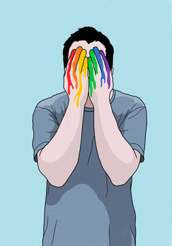 Man covering face with rainbow painted hands