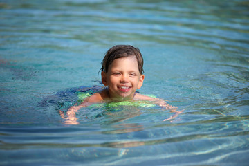 Ein Junge planscht in einem Swimmingpool