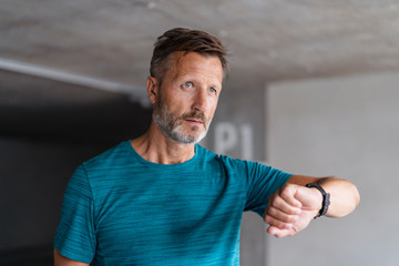 Portrait of a sporty man checking his smartwatch