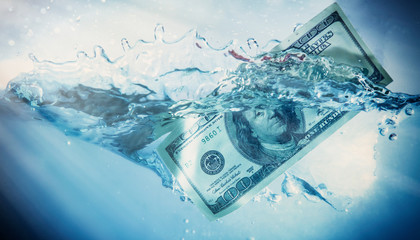 Global financiall crisis concept. Dramatic image of US Dollar sinking in water