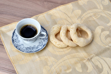 cup of coffee with cookie on table with background