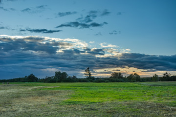 Fototapeta na wymiar Meadow and clouds after sunset