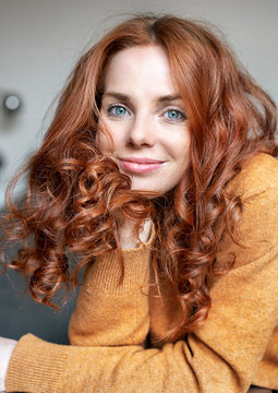 Close-up portrait of beautiful redhead woman at home