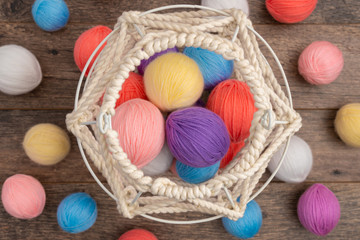 Colorful yarn balls and white knit basket