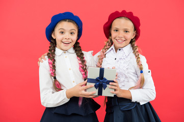 Education is the gift that continues to give. Happy little girls holding gift box on pink background. Small children smiling with gift pack. Adorable kids with beautifully wrapped birthday gift box