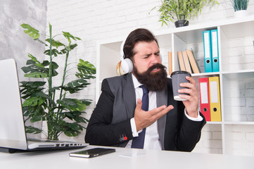 Successful businessman. Man office worker listening music headphones. Regular morning in office. Motivational music. Stress resistance concept. Manager relaxing with favorite music and cup of coffee