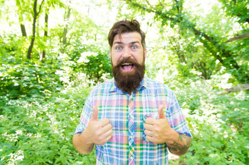 Naklejka na ściany i meble Just give a thumbs up. Happy guy gesturing thumbs ups on summer landscape. Hipster with mustache and beard extending hands with thumbs ups sign. Bearded man smiling with thumbs ups