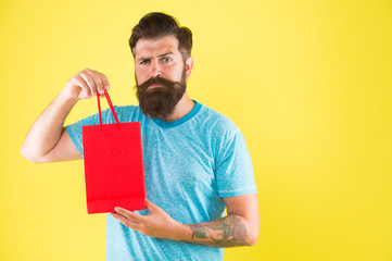 Male motives for shopping appear to be more utilitarian. Aspects can influence customer decision making behavior. Hipster hold shopping bag. Man with purchase. Impulse purchase. Purchase concept