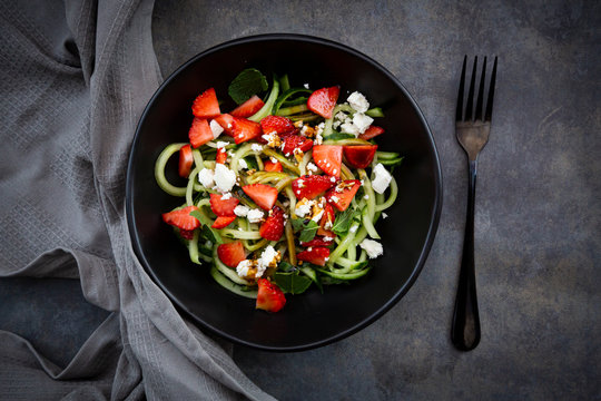 Bowl of strawberry cucumber salad with feta, mint and balsamic vinegar