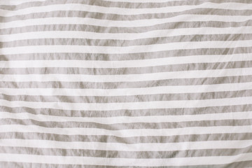Fabric texture background. Wrinkled, crumpled fabric. Top view of unmade bed sheet after night sleep. Soft focus