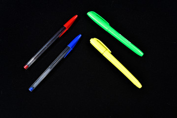 colorful ballpoint pens on black background