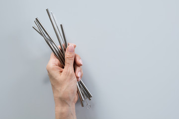 Metallic reusable straws and brush in female hand. Sustainable lifestyle. Zero waste concept, plastic free. © svetlana_cherruty