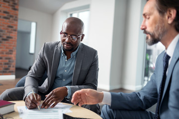 Bearded tax lawyer speaking with client signing agreement