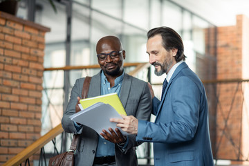 Grey-haired boss feeling satisfied with work of his employee