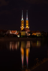 Fototapeta na wymiar WROCLAW, POLAND - August 05, 2019: Night cityscape. Historical district „Ostrow Tumski” Poland with the spires illuminated of the cathedral of St. John the Baptist...