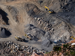Excavator loading dumper truck on mining site stock photo