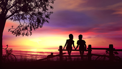 Fototapeta na wymiar A boy and a girl sitting on the fence against bright sea sunset