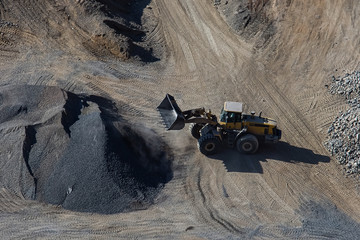 Excavator loading bucket on mining site stock photo