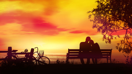 Couple on a bench watching the evening ocean after a bike ride