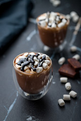 hot chocolate marshmallow in a clear glass with chocolate sause.
