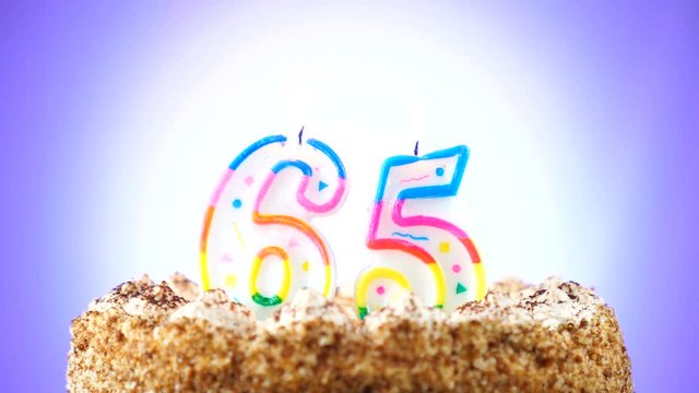 Birthday cake with a burning birthday candle. Number 65. Background changes color