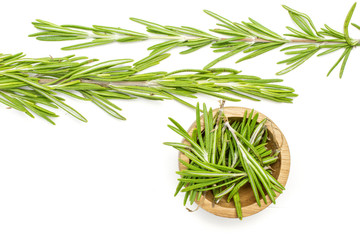 Group of two whole lot of pieces of fresh evergreen sprig of rosemary in a wooden bowl flatlay isolated on white background