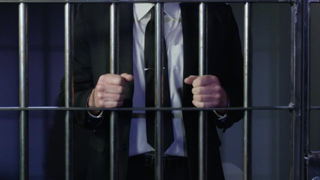 White collar criminal in jail behind bars