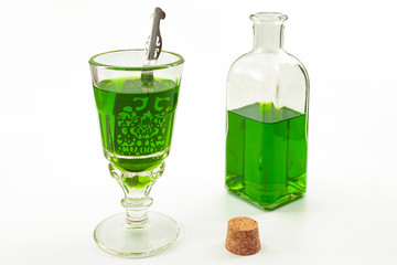 Alcoholic drink derived from botanical plants concept theme with vintage glass, metal spoon and...