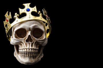 Happy Halloween, Monarchy and Dead King concept theme with a human skull wearing a shiny gold crown isolated on black background with high contrast and a clip path cut out and copy space