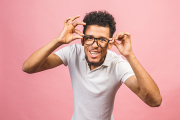 Fototapeta premium Soon to be startup owner or salesman. Portrait of cool and handsome african male student looking at camera smiling isolated against pink background.