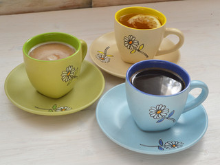Colorful cups with hot coffee, cappuccino and tea. Set with different cups of coffee and tea