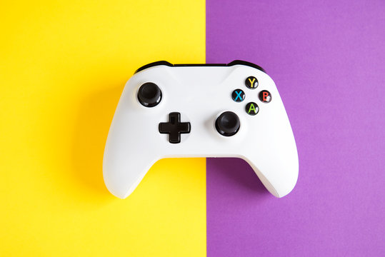 Computer gaming competition. Gaming concept. White joystick on yellow and purple background.