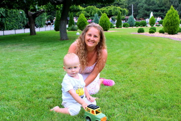 mom with little son playing on the grass in the summer park