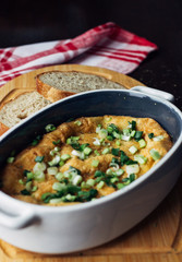 egg shaped casserole on the Board next to slices of bread