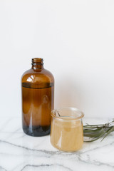 Amber Glass and Cup of Kombucha, Healthy Probiotic Drink, White and Marble Background, Copy Space