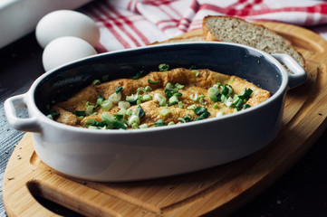 egg shaped casserole on the Board next to slices of bread