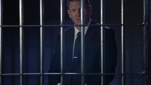 White collar criminal in jail behind bars